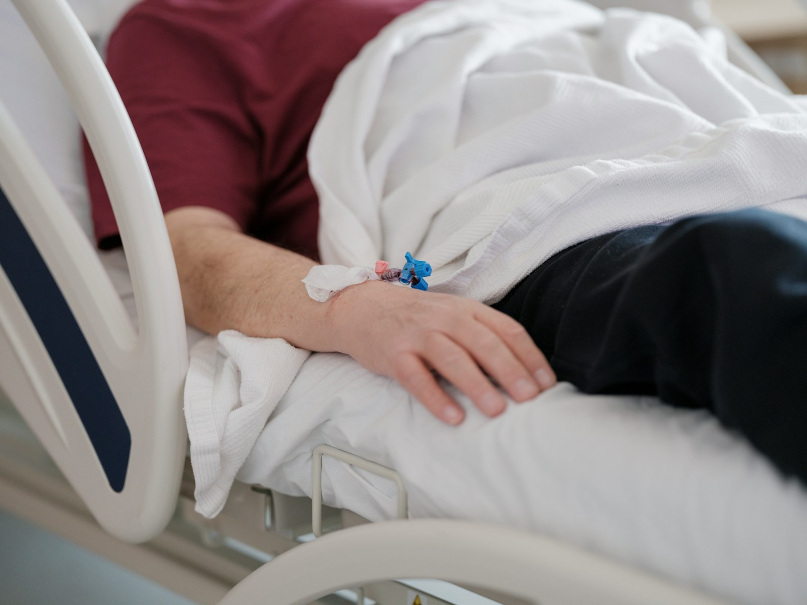 a man laying in a hospital bed with a cast on his arm, health, old